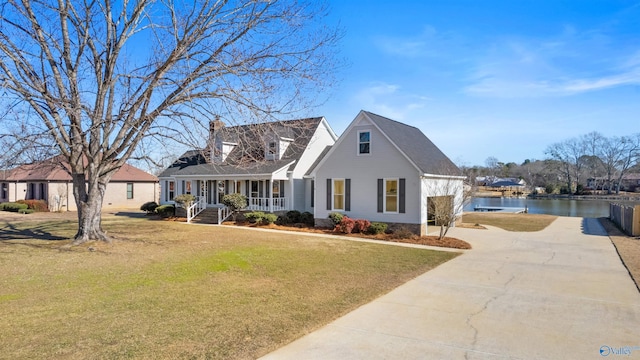 cape cod-style house featuring a water view, a porch, and a front yard