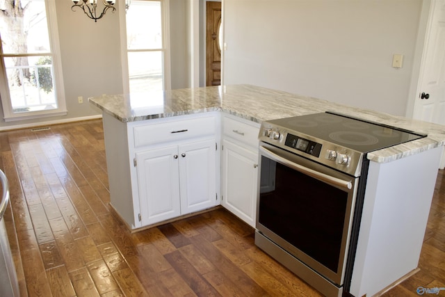 kitchen featuring white cabinets, dark hardwood / wood-style flooring, stainless steel range with electric stovetop, and an inviting chandelier