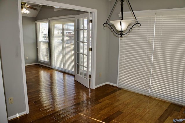 unfurnished dining area with ceiling fan, dark hardwood / wood-style flooring, and lofted ceiling