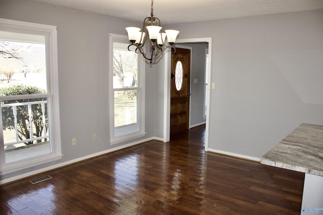 unfurnished dining area featuring dark hardwood / wood-style floors and a notable chandelier