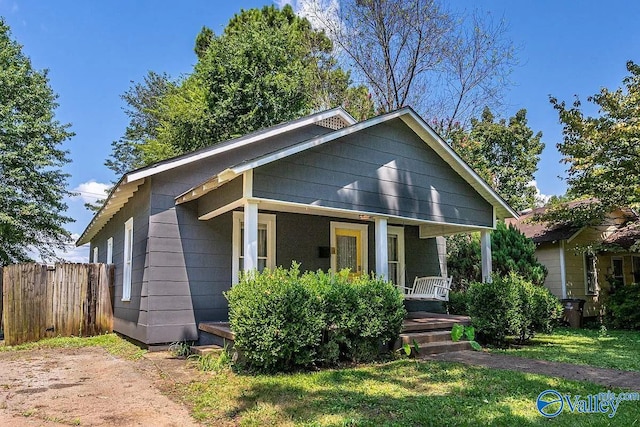 bungalow with covered porch and fence