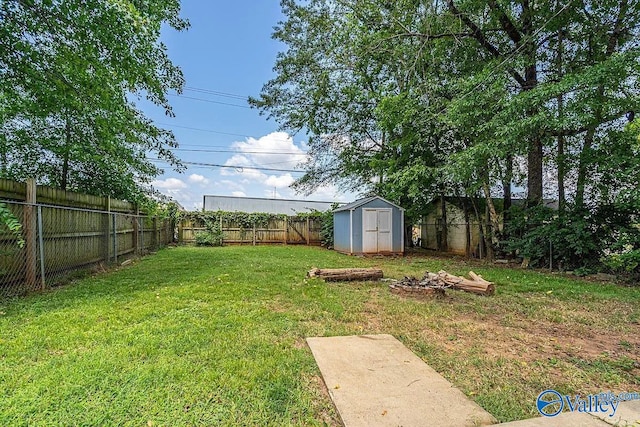 view of yard featuring a fenced backyard, a storage unit, and an outdoor structure