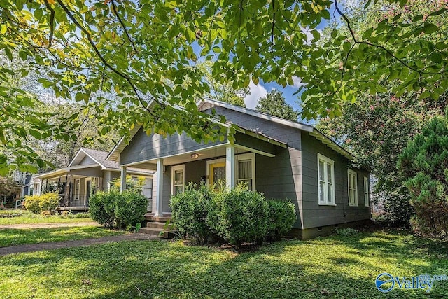 view of front of home featuring crawl space, covered porch, and a front lawn