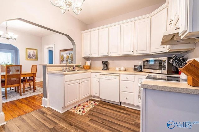 kitchen with stainless steel microwave, dishwasher, an inviting chandelier, arched walkways, and a sink