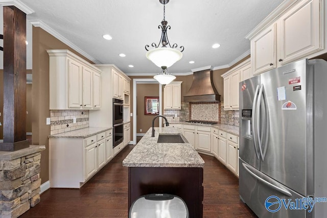 kitchen featuring premium range hood, pendant lighting, sink, light stone counters, and stainless steel appliances