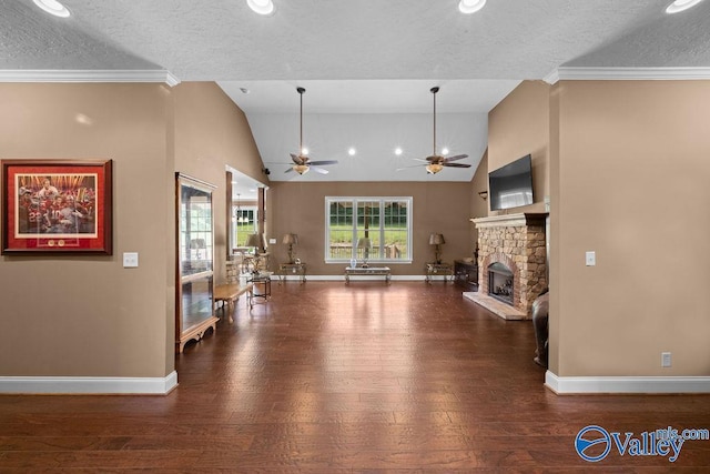 interior space with dark hardwood / wood-style flooring, a stone fireplace, lofted ceiling, and a textured ceiling