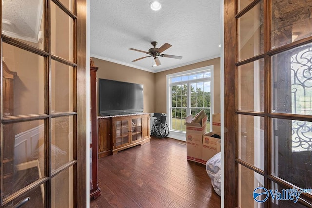 living room featuring crown molding, dark hardwood / wood-style floors, ceiling fan, and a textured ceiling