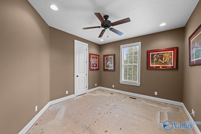 unfurnished room with ceiling fan and a textured ceiling