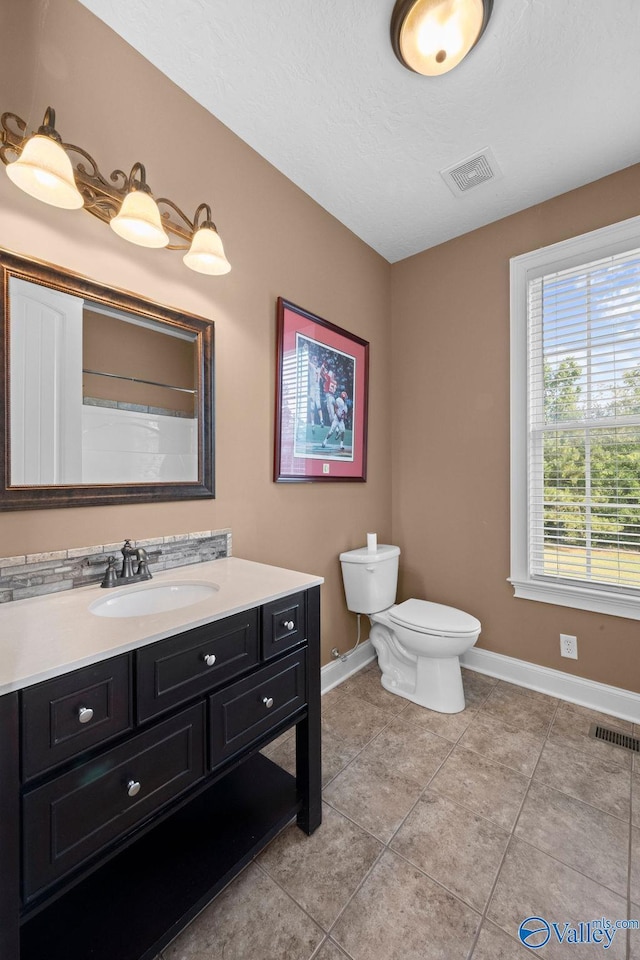 bathroom with vanity, walk in shower, tile patterned floors, and toilet