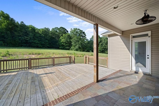 wooden deck featuring a lawn and ceiling fan