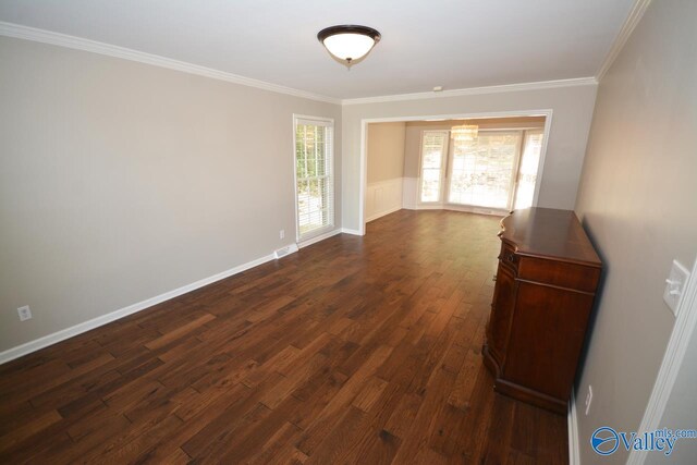 empty room with crown molding and dark wood-type flooring