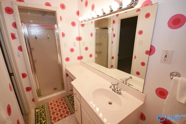 bathroom featuring tile patterned flooring, vanity, and a shower with shower door