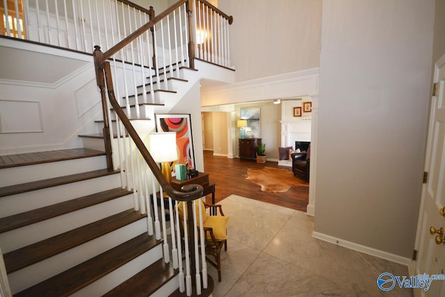 stairs with a towering ceiling and hardwood / wood-style floors