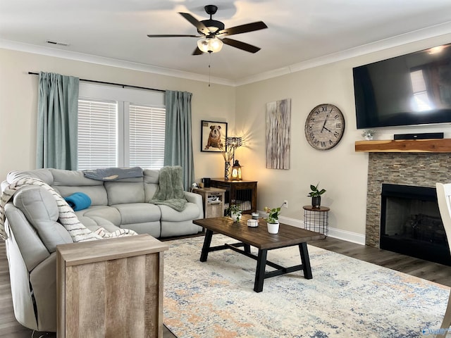 living area with visible vents, wood finished floors, baseboards, and ornamental molding