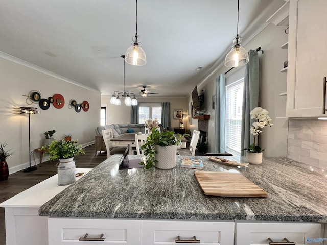 kitchen with open floor plan, plenty of natural light, a fireplace, and white cabinetry