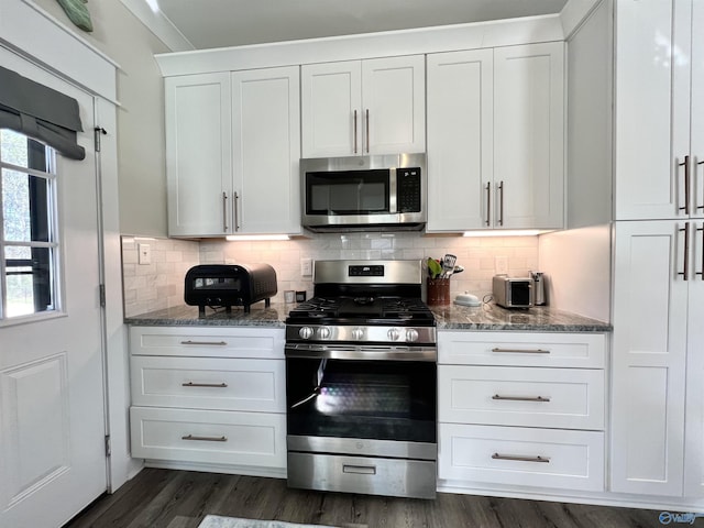 kitchen with tasteful backsplash, dark stone countertops, and stainless steel appliances