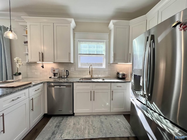 kitchen featuring decorative backsplash, open shelves, stainless steel appliances, and a sink