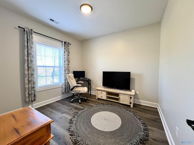 living area with dark wood finished floors, visible vents, and baseboards