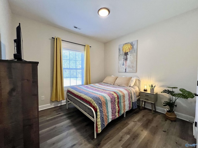 bedroom featuring wood finished floors, visible vents, and baseboards