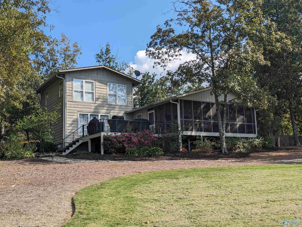 back of house featuring a sunroom and a yard