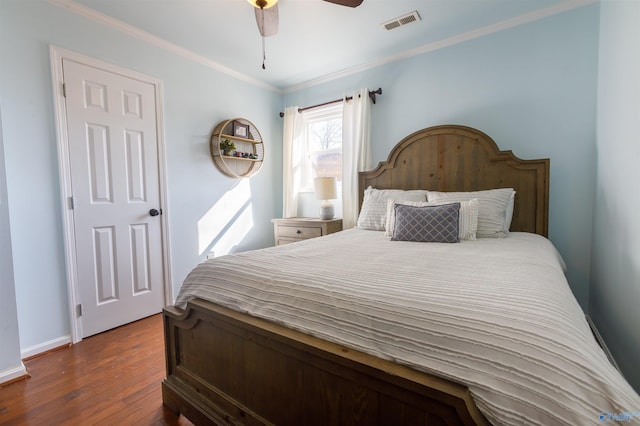 bedroom featuring ceiling fan, dark wood-type flooring, and ornamental molding