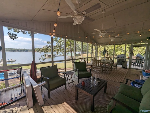 sunroom / solarium with a water view, ceiling fan, and lofted ceiling