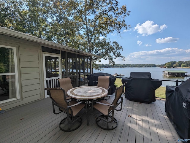 deck featuring area for grilling, a sunroom, and a water view