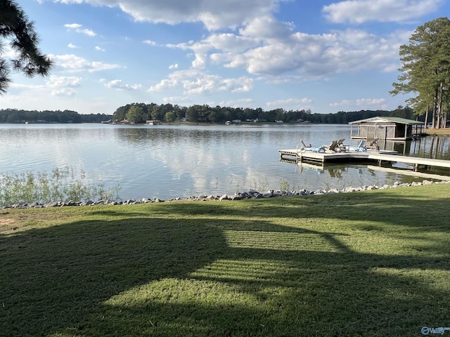 view of dock with a yard and a water view