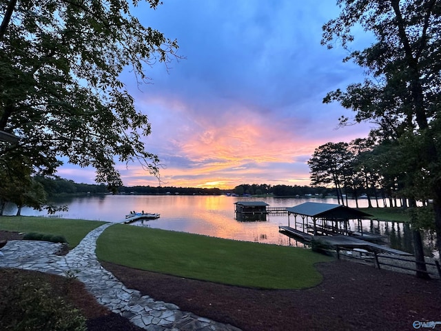 view of dock with a water view and a yard