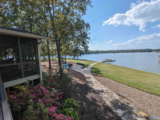 view of yard with a sunroom and a water view