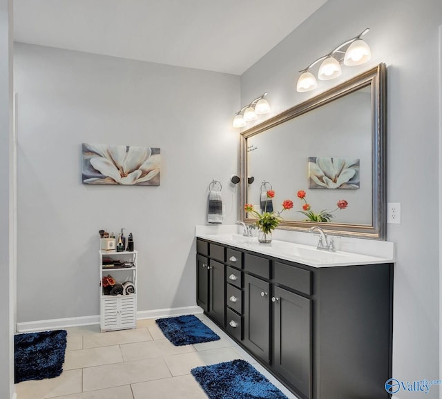 full bath featuring double vanity, tile patterned flooring, baseboards, and a sink