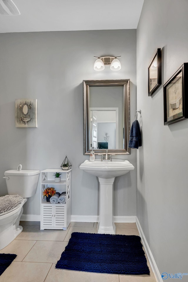 bathroom with toilet, baseboards, visible vents, and tile patterned flooring