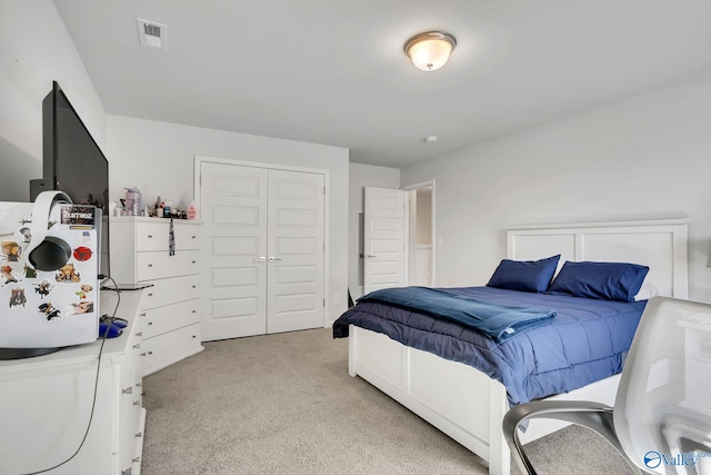 bedroom with light carpet, visible vents, and a closet