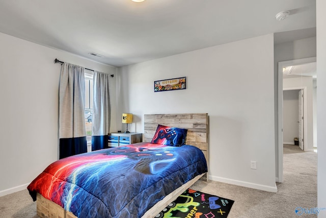 carpeted bedroom featuring baseboards, visible vents, and attic access