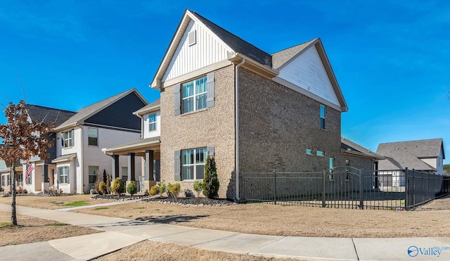 view of side of home featuring board and batten siding and fence