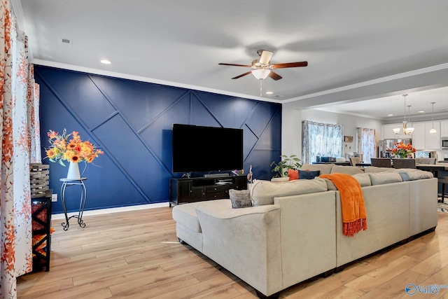 living room with ceiling fan with notable chandelier, recessed lighting, light wood-style flooring, and crown molding