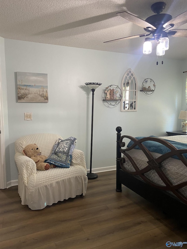 bedroom featuring a textured ceiling, wood finished floors, baseboards, and a ceiling fan