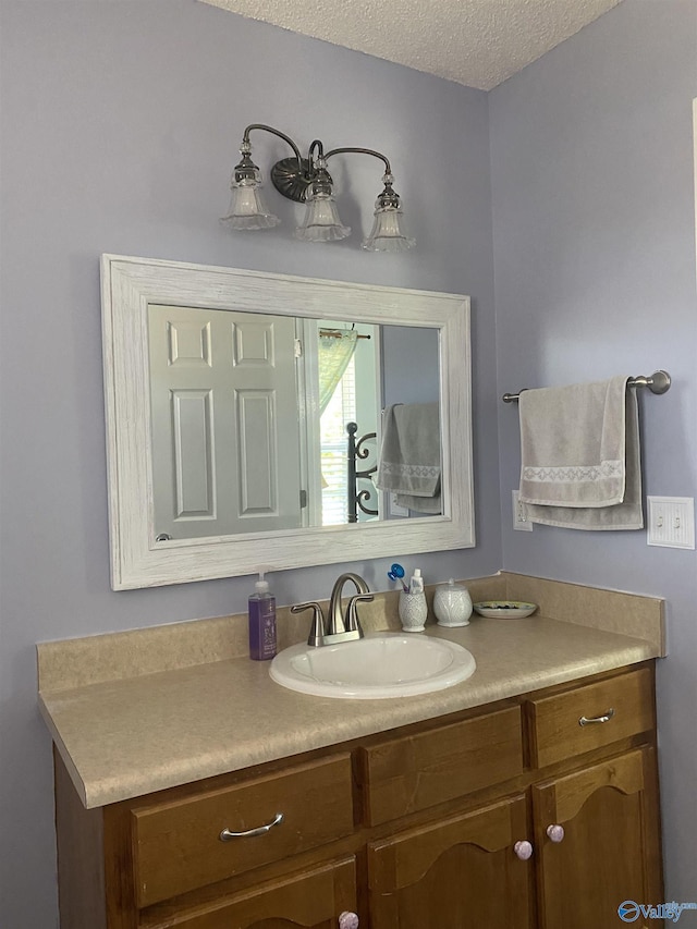 bathroom featuring a textured ceiling and vanity