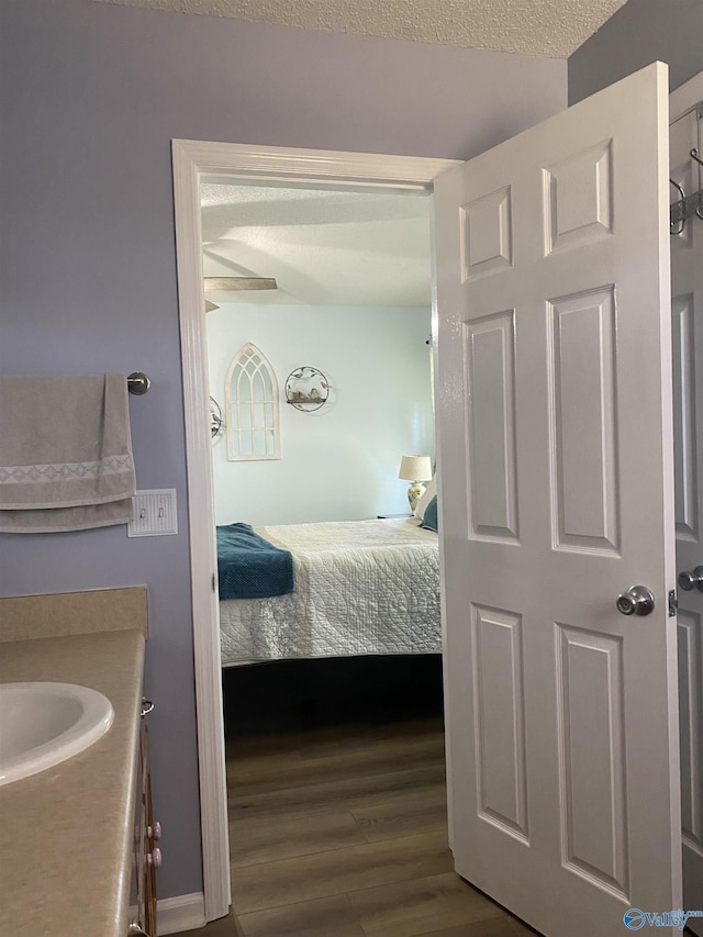bedroom with dark wood-type flooring and a sink