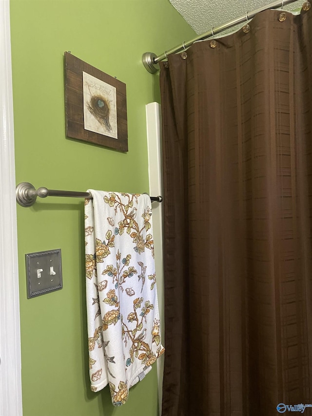 bathroom featuring a textured ceiling and a shower with shower curtain