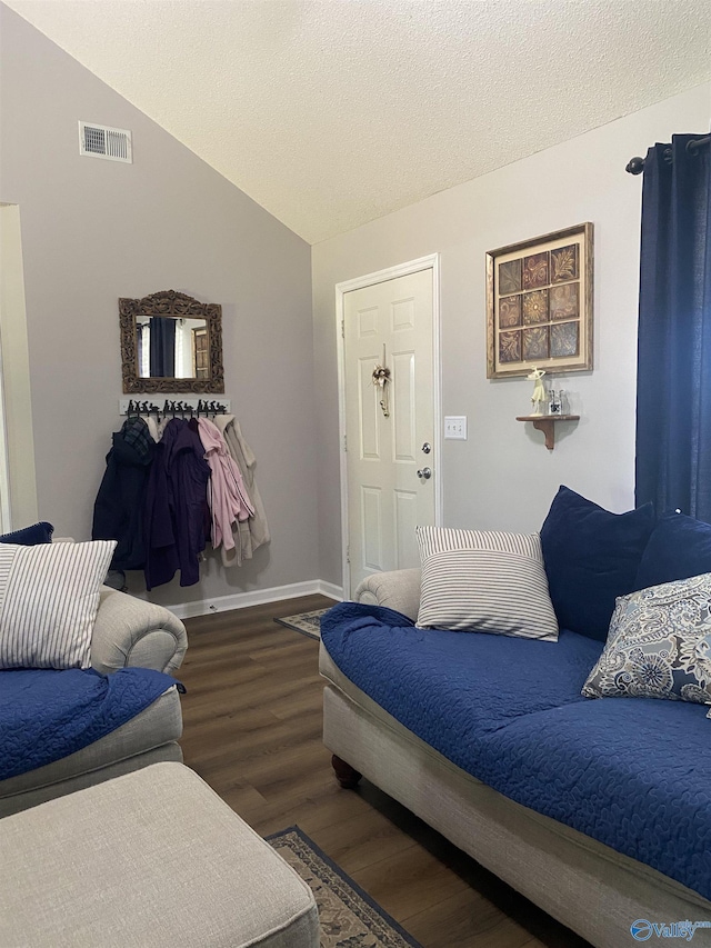 living room with visible vents, baseboards, a textured ceiling, vaulted ceiling, and wood finished floors