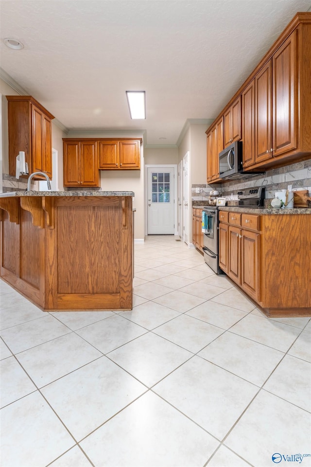 2115 James Dr, Southside, AL 35907 - kitchen with stainless steel appliances, brown cabinets, stone countertops, decorative backsplash, and crown molding