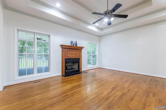 2115 James Dr, Southside, AL 35907 - unfurnished living room with ornamental molding, a raised ceiling, a fireplace with flush hearth, wood finished floors, and baseboards