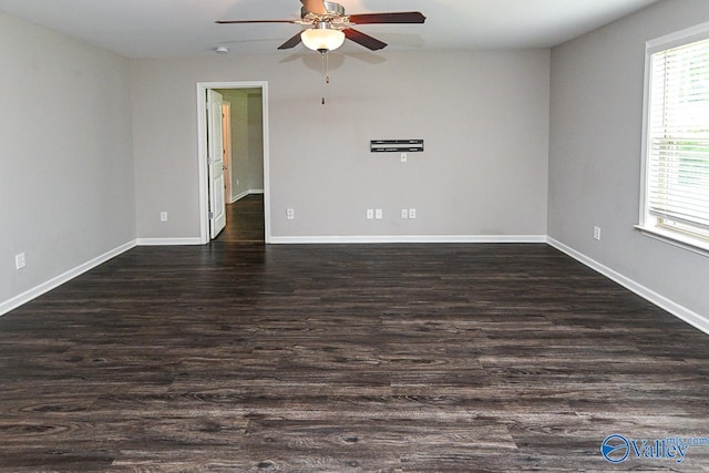 spare room with baseboards, a ceiling fan, and dark wood finished floors