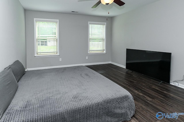 bedroom with baseboards, visible vents, multiple windows, and dark wood-type flooring