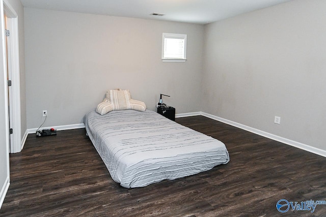 bedroom featuring visible vents, baseboards, and wood finished floors