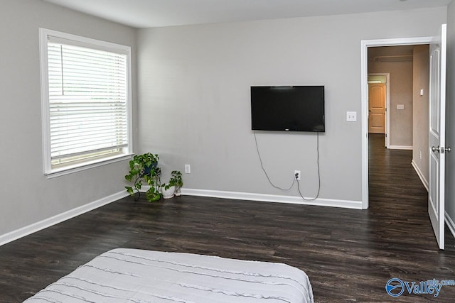 bedroom with baseboards and wood finished floors