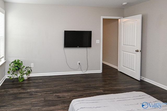 bedroom featuring baseboards and wood finished floors