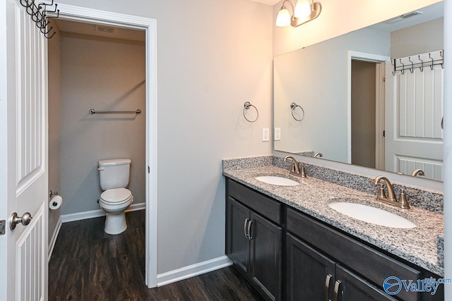 full bathroom with baseboards, a sink, wood finished floors, and visible vents