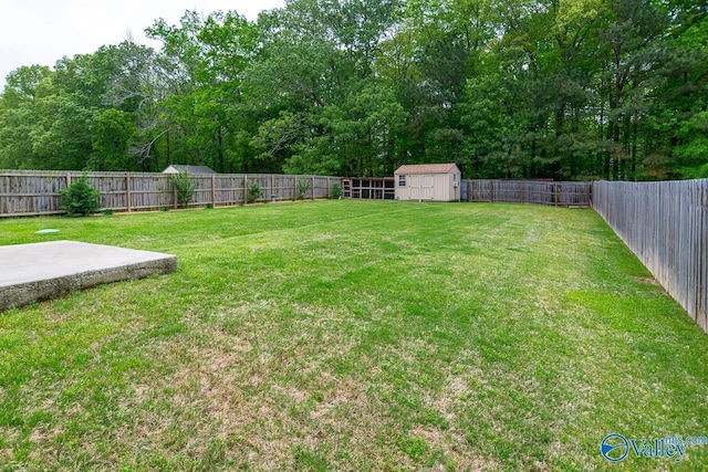 view of yard with a storage shed, an outbuilding, a fenced backyard, and a patio area